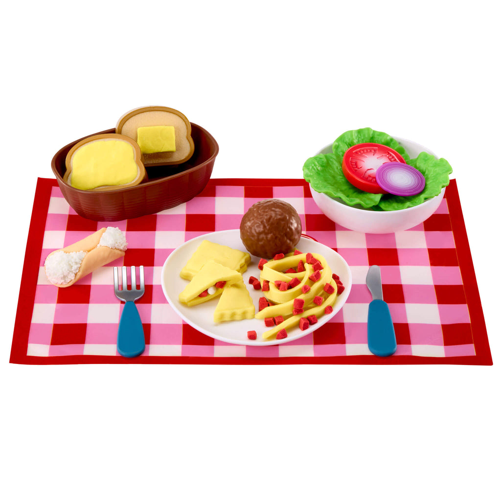 Playset food items including bread, vegetables, and a plate on a red checkered tablecloth.